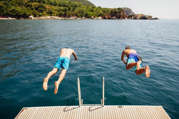 Homens pulando na água do mar a partir de iate — Fotografia de Stock