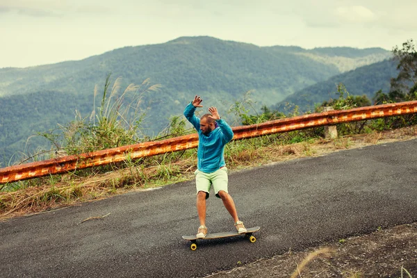 Hipster man longboarding uiterst actie in snelweg tropen — Stockfoto