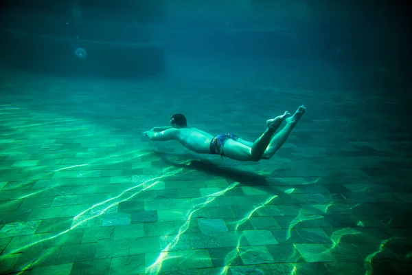 Человек плавает под водой бассейн — стоковое фото