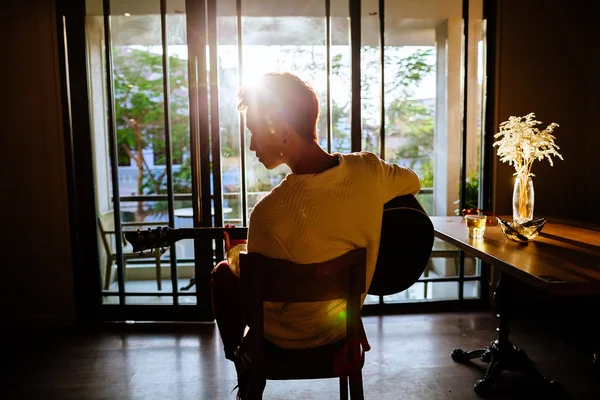 Asiatischer Künstler spielt Gitarre im Café Sonnenlicht — Stockfoto