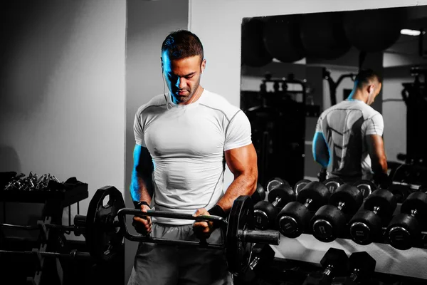 Bodybuilder pumping up hands in gym — Stock Photo, Image