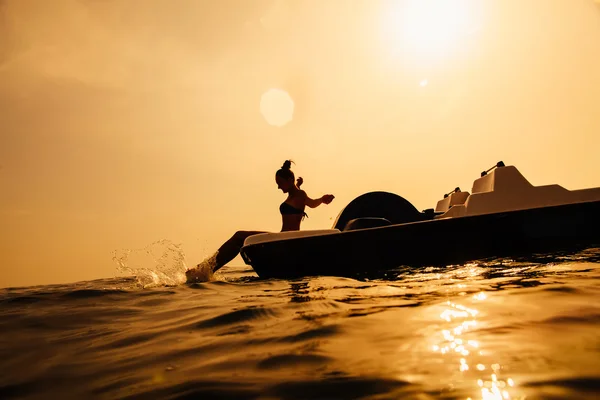 Meisje op peddel boot catamaran met zonlicht en splash — Stockfoto