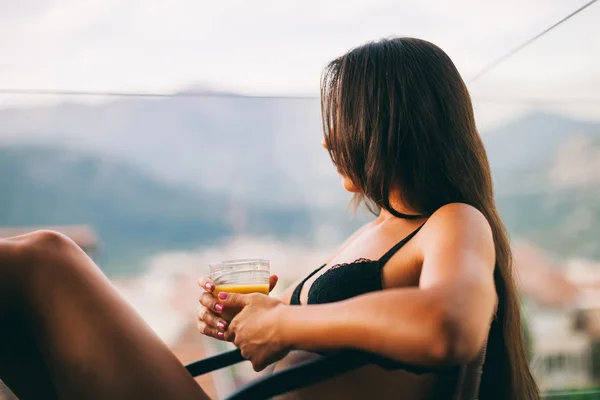 Сексуальна жінка п'є сік на домашньому балконі — стокове фото