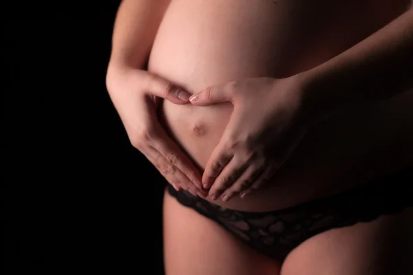 Closeup of pregnant woman make hands heart shape — Stock Photo, Image