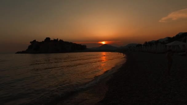 Puesta de sol en la pintoresca playa de la isla de Sveti Stefan — Vídeo de stock
