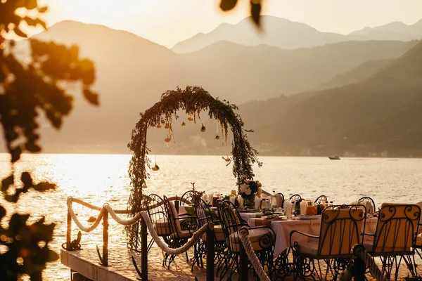 Destination wedding arch and banqouet covered table at sunset — Stock Photo, Image