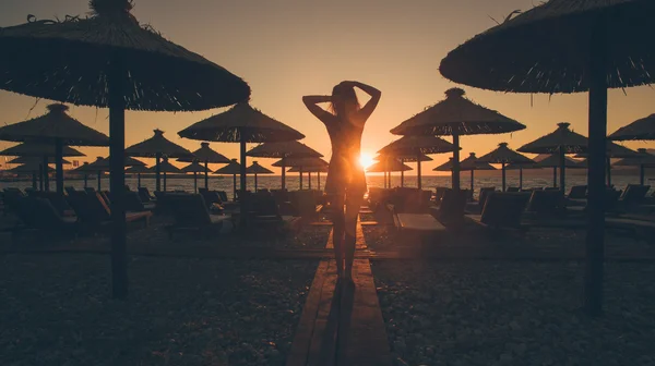 Sexy vrouw lopen op het strand bij zonsondergang — Stockfoto