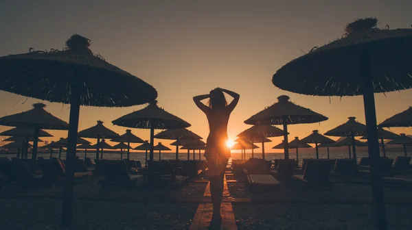 Sexy vrouw lopen op het strand bij zonsondergang — Stockfoto