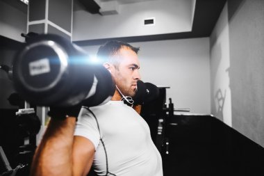 spor salonunda vücut geliştirmeci adam pompalama eller