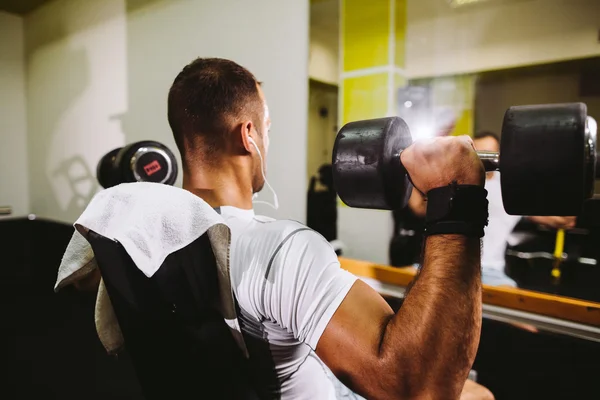 Culturista chico bombeo manos en el gimnasio — Foto de Stock