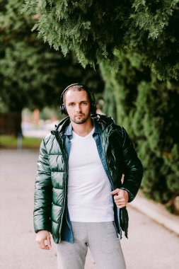 Beyaz tişört ve ceket giyen adam.