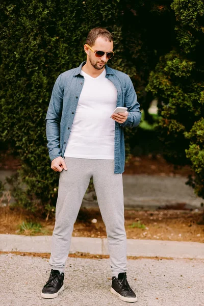 Mann in weißem T-Shirt mit Handy-Attrappe — Stockfoto