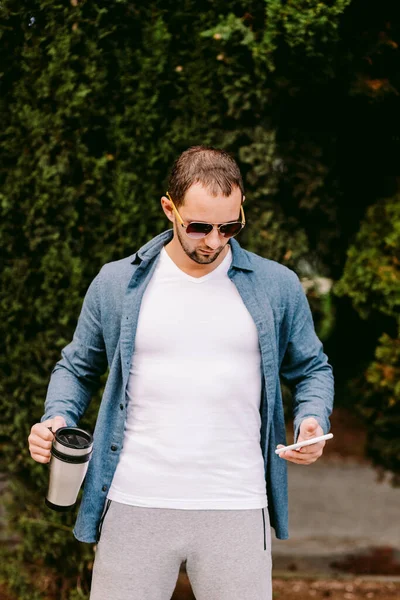 Mann trägt weißes T-Shirt mit Handy-Attrappe — Stockfoto