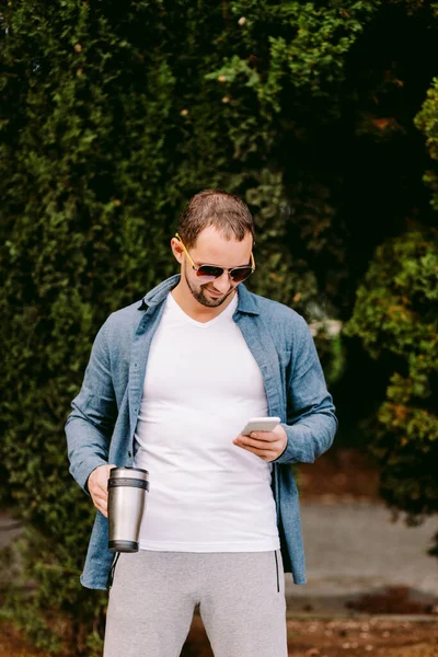 Mann in weißem T-Shirt mit Handy-Attrappe — Stockfoto