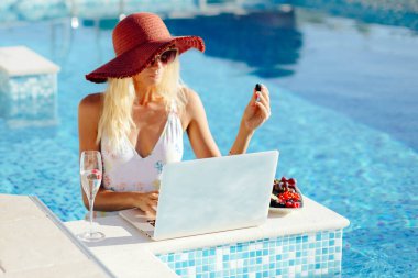 Laptop kullanan ve uzaktan çalışan serbest çalışan bir kadın. 