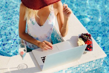 Laptop kullanan ve uzaktan çalışan serbest çalışan bir kadın. 