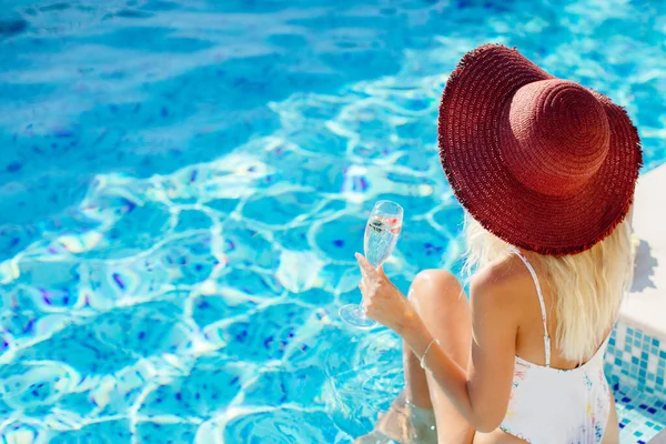 Wanita seksi santai di kolam renang dan minum sampanye — Stok Foto