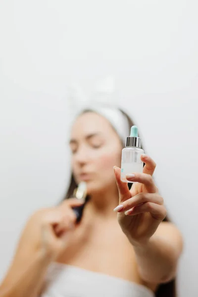 woman using face serum after cleansing and toning