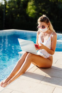 Yüz maskesi takan genç bir kadın. 