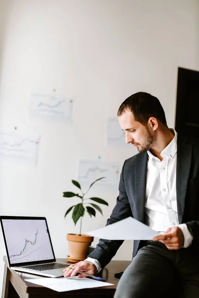 Manager finanziario analizzando grafico andamento dei dati di prezzo sul computer portatile in ufficio — Foto Stock