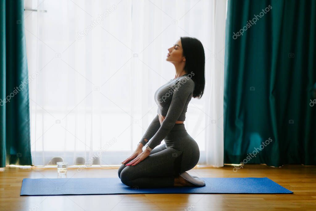 Young attractive woman practicing yoga at home. stretching practice