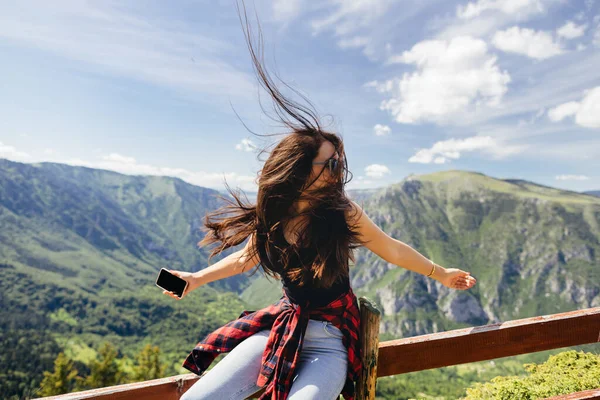 Belle femme se détendre dans les montagnes avec smartphone — Photo