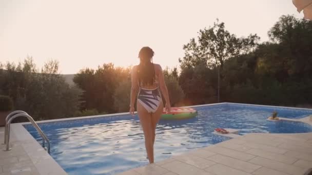 Žena relaxovat v bazénu při západu slunce — Stock video