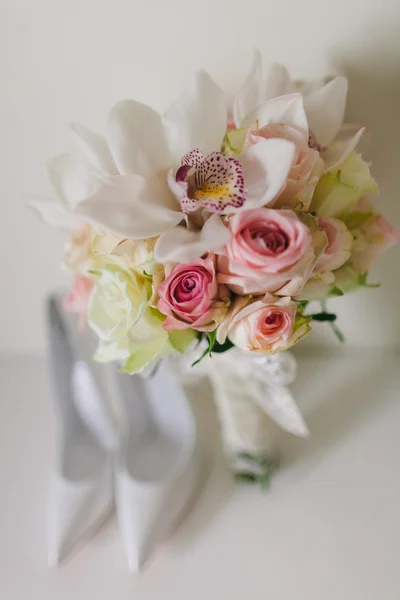 Wedding bouquet  with orchids and roses and wedding bride's shoe — Stock Photo, Image