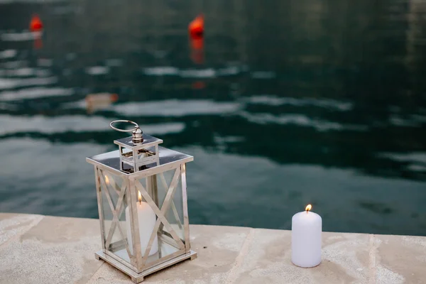 Candele romantiche sul molo vicino all'acqua — Foto Stock