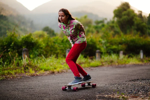 Adolescente longboarding menina nas montanhas — Fotografia de Stock