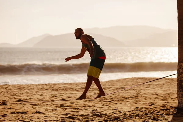 Teenage balanceren op slackline met uitzicht op zee — Stockfoto