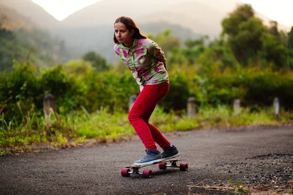 Genç kız longboarding dağlarda — Stok fotoğraf