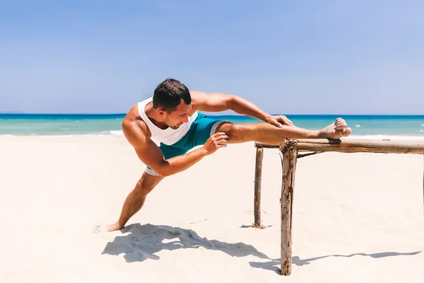 Mężczyzna w stretching na plaży — Zdjęcie stockowe