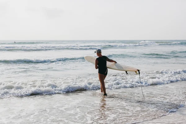 Surferin mit Surfbrett Rückansicht — Stockfoto