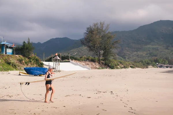 Vrouw met surfen bestuur surfen op het strand — Stockfoto