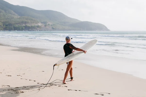 在海滩上的冲浪板的女人 — 图库照片