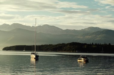 Yat ve tekne ile Kotor Koyu'ndaki dağlarda gün batımında zevk