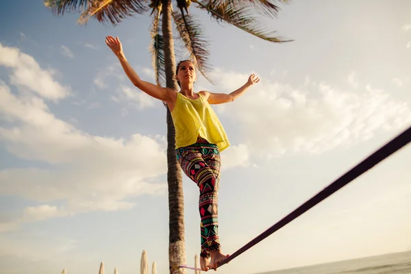 Nastolatka balansując na slackline z widokiem na niebo — Zdjęcie stockowe