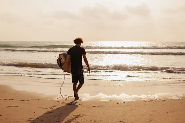 Surfing man siluett på stranden — Stockfoto