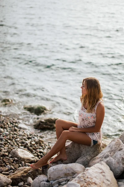 Drömmande flicka på stranden med havsutsikt — Stockfoto