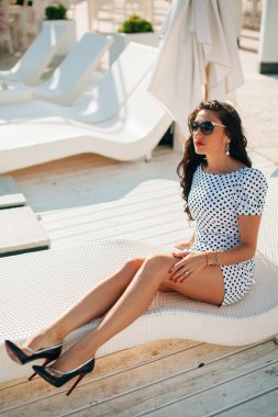 lüks esmer uzun bacaklı bayan manken şezlong üzerinde