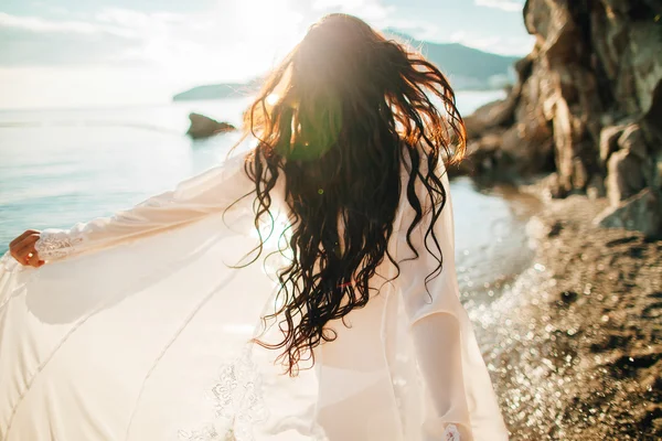 Vento in capelli ragazza sognante con raggi di sole sulla spiaggia Foto Stock