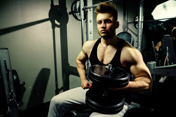 Güçlü vücut geliştirmeci atlet spor salonunda ağır dumbbells ile — Stok fotoğraf