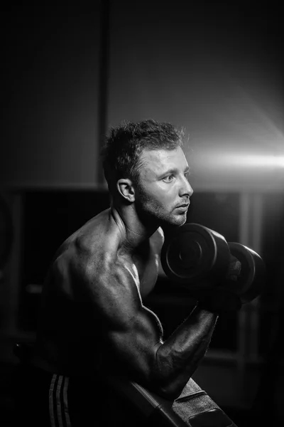 Musculoso guapo culturista chico con dumbbell monocromo — Foto de Stock