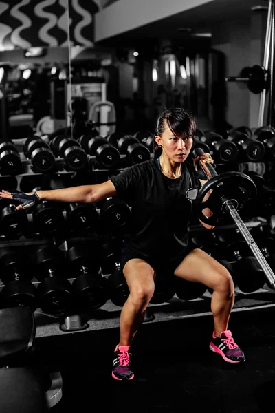 亚洲性感健身女孩膝盖弯举重在健身房 — 图库照片