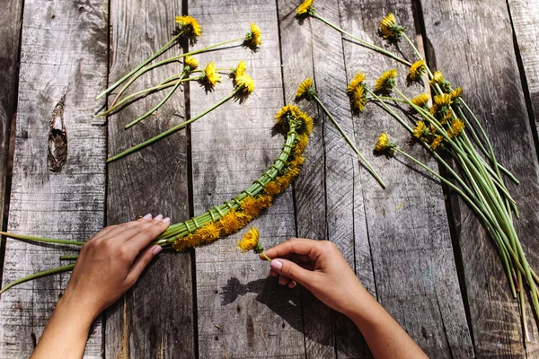 Венок из одуванчиков цветы ручной работы на деревянный стол — стоковое фото
