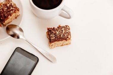 Bisküvi ve beyaz masa üstten görünüm smartphone ile kahve fincanı