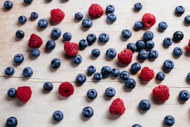 Ahududu ve yaban mersini sulu vitamini koleksiyonu ahşap masa üstü görünümü