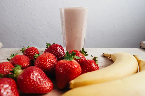 Strawberry banana smoothie fresh blended on wood table — Stock Photo, Image