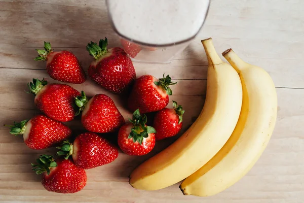 Aardbeien-Banaan smoothie vers gemengd op houten tafel — Stockfoto